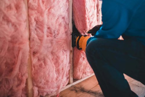 person putting insulation foam on wall